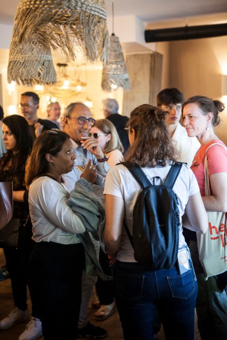 Groupe de personnes en discussion dans un espace lumineux et animé.