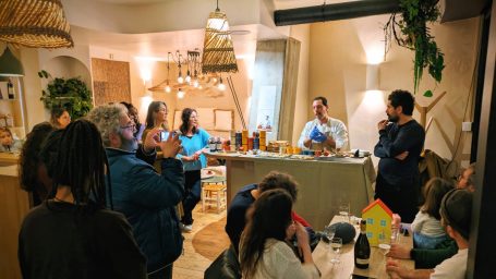 Un groupe de personnes assiste à une démonstration culinaire dans une cuisine moderne.