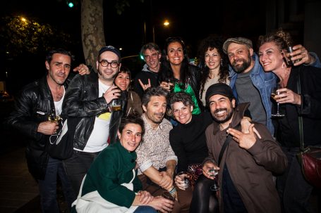 Groupe de personnes souriantes réunies lors d'une soirée en extérieur.